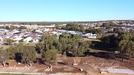 Aerial-dolly-right-over-Riverlinks-Park-all-abilities-playground-after-flooding,-April-2024