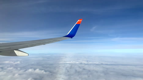 Blick-Aus-Dem-Flugzeugfenster-Zum-Horizont-über-Den-Wolken-Bei-Tageslicht
