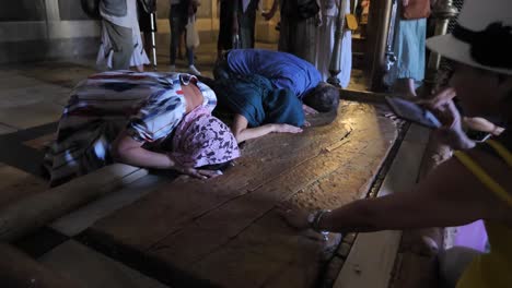 Peregrinos-Orando-Junto-A-La-Piedra-De-La-Unción-En-La-Iglesia-Del-Santo-Sepulcro