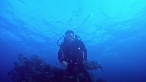 Taucher-Schwimmt-über-Dem-Kameramann-Und-Zeigt-Ihm-Ein-Zeichen