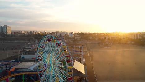Gorgeous-aerial-pan-around-Santa-Monica-ferris-wheel-during-sunrise-golden-hour