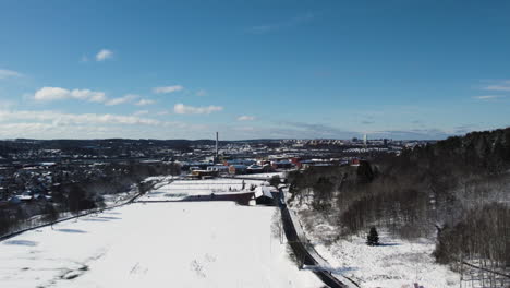 Kviberg-Park-Covered-in-Snow-at-Winter,-East-Gothenburg-Cityscape,-Aerial-View
