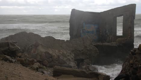 Grandes-Olas-Golpeando-Las-Ruinas-Del-Edificio-De-Defensa-Costera-De-Hormigón-Abandonado-Con-Graffiti-En-Tiempo-Tormentoso