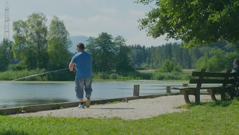 wide-panning-shot-of-a-man-fishing-in-a-lake