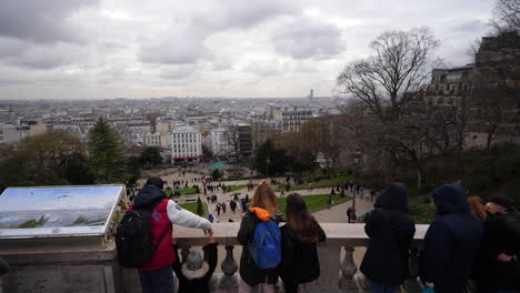 Overhead-moving-shot-of-tourists-looking-out-over-the-city-of-Paris-from-the-terrace-of-the-Sacre-Coeur-Basilica-during-a-cloudy-winter's-day