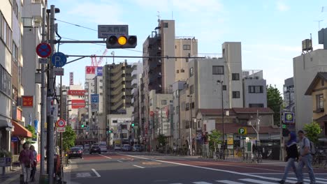 Autoverkehr-In-Tokio-Asakusa-Mit-Fußgängern,-Die-Auf-Einem-Zebrastreifen-Die-Umamichi-Dori-Straße-überqueren