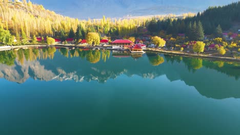 Vuelo-Aéreo-Sobre-El-Tranquilo-Y-Reflectante-Lago-Kachura-Inferior,-También-Conocido-Como-Lago-Shangrila-Cerca-De-Skardu-En-Gilgit-baltistan-Con-Complejos-Turísticos