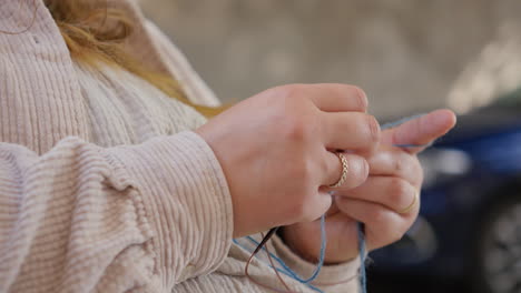 Close-up-of-hands-knitting-with-blue-yarn,-craft-hobby-concept