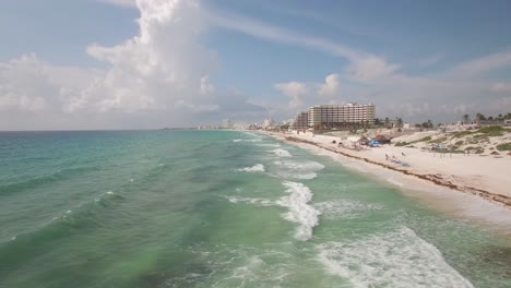 Aerial-dolly-from-ocean-to-beach-in-Cancun,-Mexico