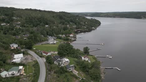 Aerial:-Docks,-boats-line-lakeshore-of-Nordic-boreal-lake-in-Sweden