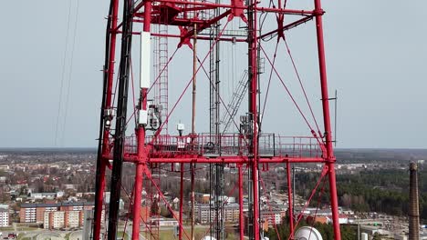 White-Red-metallic-communication-tower-with-satellite-devices-aerial-drone-closeup