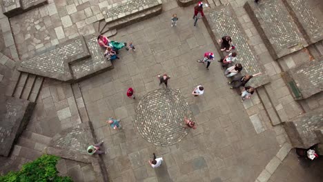 Young-men-doing-a-backflip-simultaneously-during-a-Parkour-session-in-a-top-shot-aerial-footage-during-a-sunny-day-in-Yeats-Memorial-Dublin,-Ireland