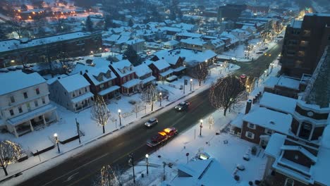 Aerial-establishing-shot-of-Main-Street,-Small-Town-America,-storefronts-and-colonial-homes-in-United-States-historic-town-during-winter-snow