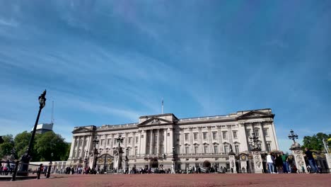 Front-view-of-Buckingham-Palace-in-London,-England,-with-visitors-gathered-in-front