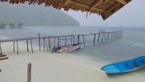 tropical-heavy-rain-seen-from-a-hut-on-Kri-Island-in-the-Raja-Ampat-Archipelago,-Indonesia