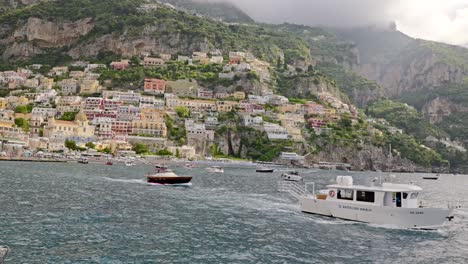 Approaching-Positano-full-of-touristic-and-jet-boats,-Positano-is-a-touristic-town-of-the-Amalfi-coast-in-Southern-Italy