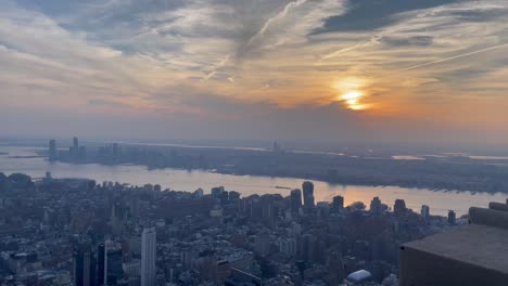 Puesta-De-Sol-Dorada-Y-Nublada-Desde-Lo-Alto-Del-Edificio-Empire-State-En-La-Ciudad-De-Nueva-York-Con-El-Río-Hudson-Al-Fondo