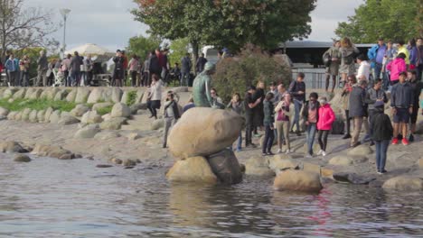 Tourist-watch-and-photograph-the-statue-of-Little-Mermaid-in-Copenhagen,-Danmark-in-sunny-day