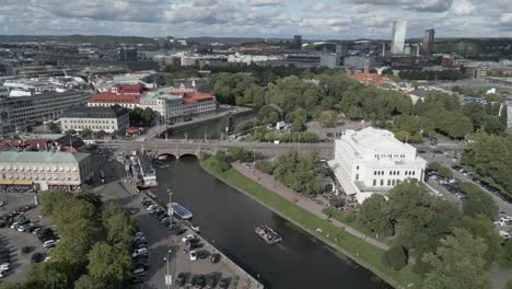 Descending-aerial:-Boat-on-Gothenburg-Sweden-canal,-Grand-Theatre