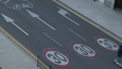 Alto-ángulo-De-Carretera-Con-Señales-De-Tráfico-Pintadas-De-Límite-De-Velocidad,-Conducción-De-Automóviles-Y-Scooters-En-Lugo,-España