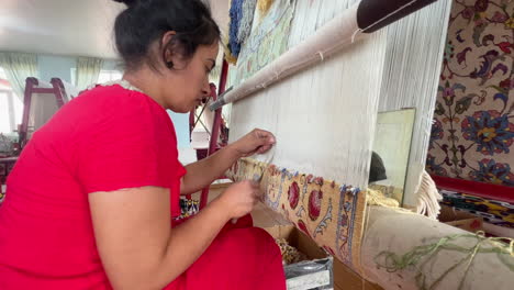 Young-woman-knotting-a-carpet-by-hand
