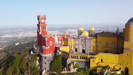 Farbenfroher-Pena-Palast-In-Sintra,-Portugal,-Nahaufnahme,-Zurück-Zur-Weiten-Landschaft:-Luftaufnahme-Per-Drohne,-Helles-Schloss-In-Der-Nähe-Von-Lissabon,-Strahlend-Sonniger-Tag