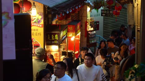 La-Gente-Deambula-Por-Una-Calle-Estrecha-Y-Bulliciosa-Flanqueada-Por-Puestos-De-Comida,-Boutiques-De-Souvenirs-Y-Pintorescas-Tiendas-De-Regalos-En-La-Antigua-Calle-Jiufen,-Un-Encantador-Pueblo-De-Montaña-En-Taiwán