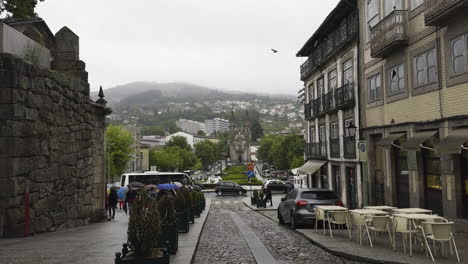 Tourists-leave-from-old-stone-wall-castle-with-quaint-home-facade-on-overcast-day