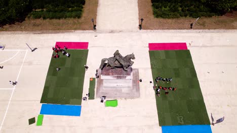 Aerial-establishing-shot-of-a-sports-event-beside-the-Statue-équestre-de-Louis-XIV