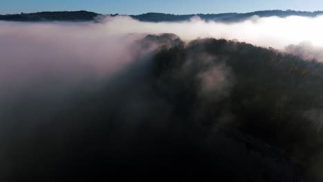 Black-mountain-with-mist-in-the-trees,-drone-shot-in-Dordogne