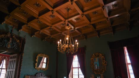 Salón-De-Música-En-El-Castillo-De-Trakošćan,-Croacia,-Con-Muebles-Ornamentados-Y-Una-Lámpara-De-Araña.