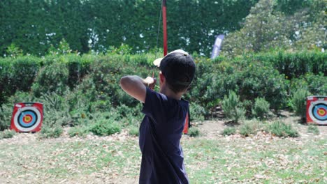 Slow-motion-shot-of-a-young-boy-firing-an-arrow-at-an-archery-target