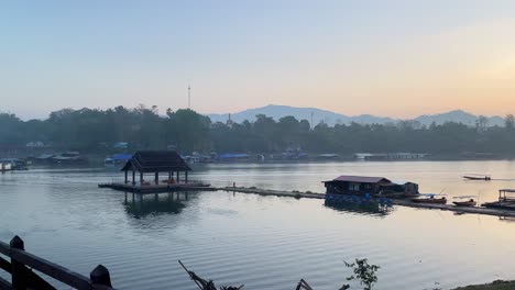 Panoramic-view-truck-left-of-the-sunset-in-Sangkhlaburi-on-the-wooden-bridge-Mon,-tourists-taking-pictures,-Thailand