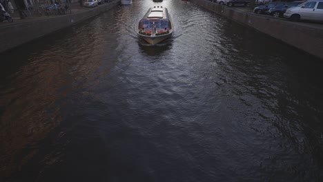 Beautifully-designed-tourist-boats-taking-people-on-tour-in-the-canal-in-Amsterdam,-Netherlands