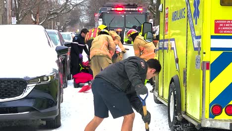 Bomberos-Ayudando-A-Una-Persona-En-Una-Calle-Nevada,-Respuesta-De-Emergencia-En-Montreal