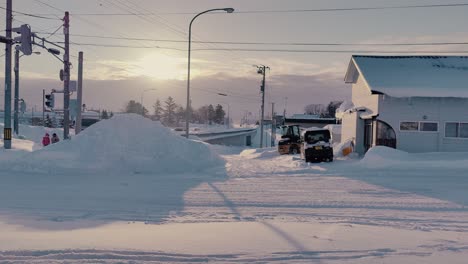 Traktor-Lädt-Schnee-In-Einen-Haufen-Neben-Schneebedeckter-Straße-In-Omu-Hokkaido-Bei-Sonnenuntergang