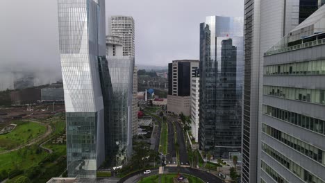 Gliding-aerial-shot-between-Santa-Fe-skyscrapers-in-Mexico-city-with-nearly-Empty-road-lanes-and-cloudy-weather-during-corona-pandemic