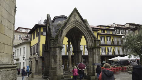 Tourists-gather-walking-around-roaming-below-skeleton-stone-spire-hut