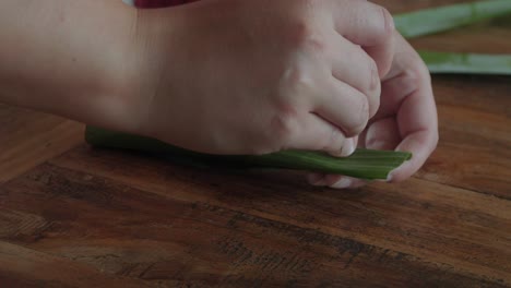 Hands-preparing-Sate-lilit-or-sataya-in-banana-leaves,-famous-Indonesian-delicacy