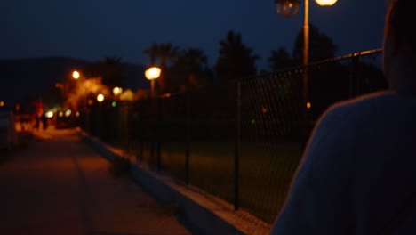 Woman-walking-along-beach-of-Kusadasi-resort-in-evening,-Turkey