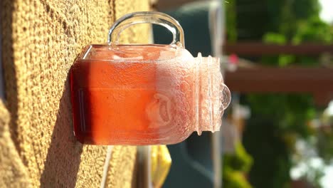 A-woma-prepares-her-strawberry-juice-with-ingredients-on-a-wooden-table,-close-up-shot,-insert-shot,-vertical-video