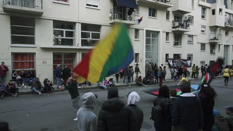 Men-waving-flags-in-a-parade-in-the-streets-of-Montevideo,-Uruguay