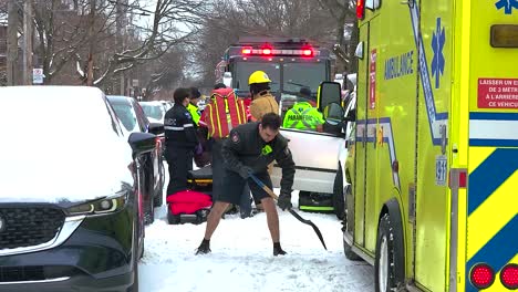 Rescue-Team-Scraping-Snow-Off-The-Street-At-Scene-Of-Motor-Vehicle-Accident-In-Montreal,-Quebec,-Canada