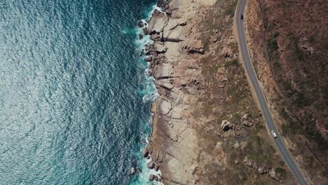 Top-down-drone-flying-over-a-scenic-route-near-the-coast-of-Cape-Town-South-Africa