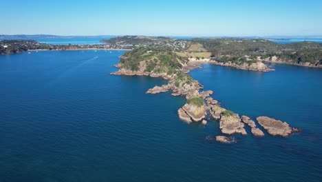 Rocas-En-La-Bahía-De-Oneroa-Con-La-Gran-Playa-De-Oneroa-En-La-Distancia