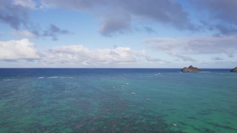 Drohnenaufnahmen-Des-Klaren,-Türkisblauen-Wassers-In-Der-Nähe-Des-Lanikai-Beach-Auf-Der-Insel-Oahu,-Hawaii,-Mit-Blauen,-Schüchternen-Und-Bauschigen-Weißen-Wolken-Und-Vulkanischen-Formationen