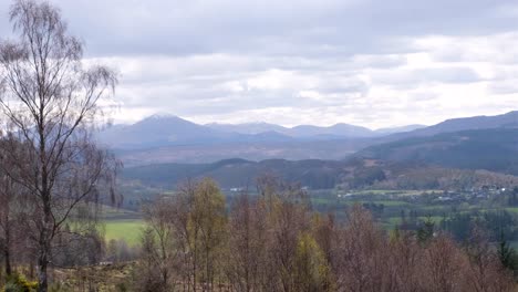 Scenic-aerial-landscape-view-of-rural-countryside-terrain-and-snow-capped-mountains-in-Fort-Augustus,-highlands-of-Scotland-UK