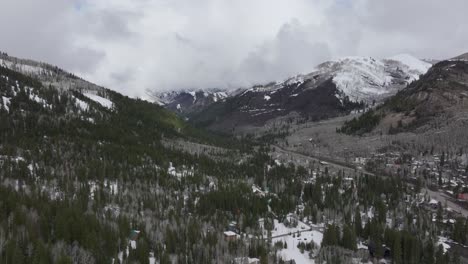 Panorámica-Aérea-De-Una-Amplia-Cordillera-Nevada-Cerca-Del-Solitude-Resort-En-El-Gran-Cañón-De-Cottonwood,-Utah-A-Finales-De-La-Primavera