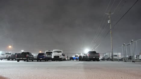 Powerful-snow-storm-over-parking-lot-in-Canada,-low-angle-static-view