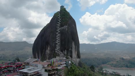 Toma-Aérea-Del-Peñón-De-Guatapé,-Una-Roca-Grande-Y-única-Que-Se-Alza-Sola-Con-Escaleras-Hacia-La-Cima-Y-Ofrece-Vistas-Panorámicas,-Guatapé,-Colombia_toma-Orbital